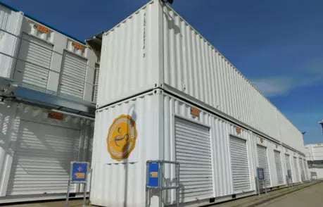 Large white container complex with multiple roll-up doors, organized for extensive storage solutions